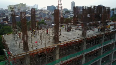 JAKARTA, INDONESIA - APRIL 2017: Panning drone shot of busy construction site, development of new office tower in Jakarta, Indonesia