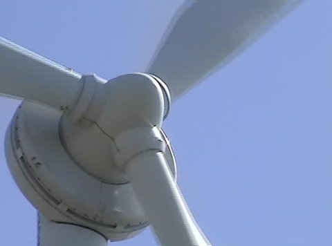 Close-up of a rotating white power-generating windmill.