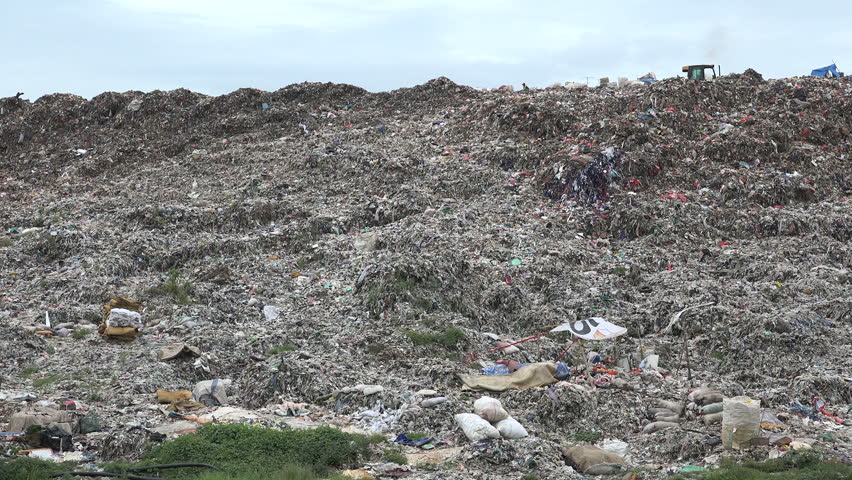 JAKARTA, INDONESIA - APRIL 2017: Lonely figure recycles garbage on a massive dumping ground in Jakarta, Indonesia | Shutterstock HD Video #29420572