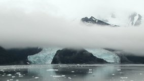View from the ship of large glacier and ice floes in Beagle Channel, Patagonia. Low clouds cover top