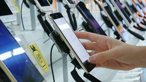 Ternopil, UKRAINE - JULY 15, 2017: Customer chooses smartphone in electronics store. Gadget showroom at electronics store, buyers testing smartphones