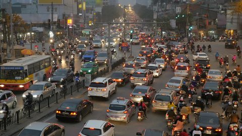 Rush hour in Hanoi, Vietnam, crowded traffic mess at intersection with cars, motorbikes, buses and many people. High angle, long shot.