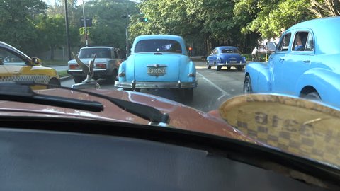 HAVANA, CUBA - FEBRUARY 2017: Slow moving vehicles, many of them American vintage cars, at a traffic light in Havana, Cuba
