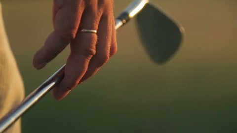 Man playing golf at sunset