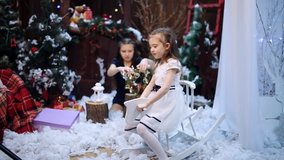 A girl is riding a wooden horse near a Christmas tree Granddaughters pack a white shawl as a present to their beloved grandmother in a gift box. - Powered by Shutterstock - Get 15% off with code: PIKWIZARD15