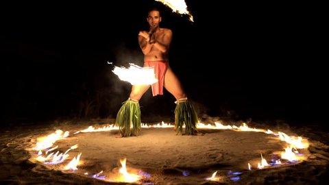 Male Polynesian Fire dancer performing in a Ring of Fire while spinning his flaming torches a tradition in French Polynesia South Pacific