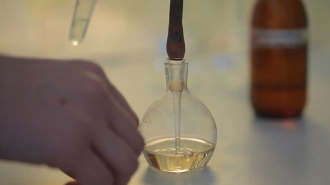 Laboratory experiment of ecology researches: take some liquid sample from the bulb by pipette. The vial has special marks in russian