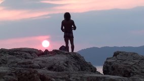 Man with tambourine praying on rock to the declining sun - Powered by Shutterstock - Get 15% off with code: PIKWIZARD15