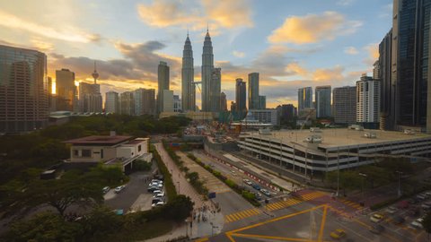 Time lapse: Kuala Lumpur city view during dramatic dusk overlooking the city skyline and a busy intersection with light trails. Motion Timelapse Zoom In .