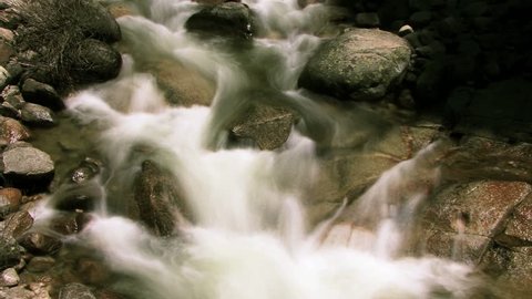 HD - A small stream flows over rocks in time lapse (Loop).