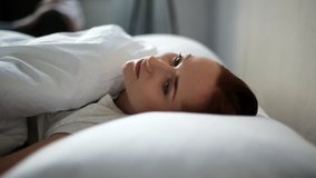 Depressed adult woman lying in bed
