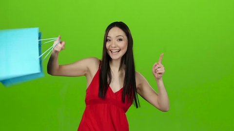 Girl received a gift, opens it and rejoices. Green screen. Slow motion