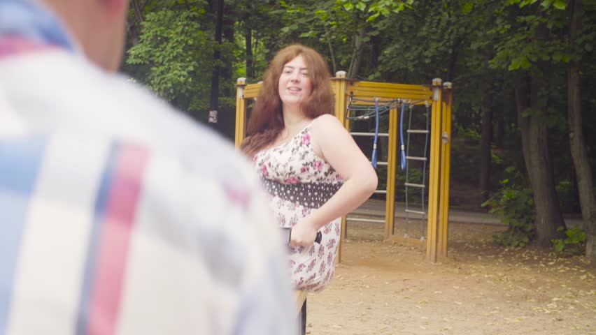 Happy parents with baby girl swinging on a swing