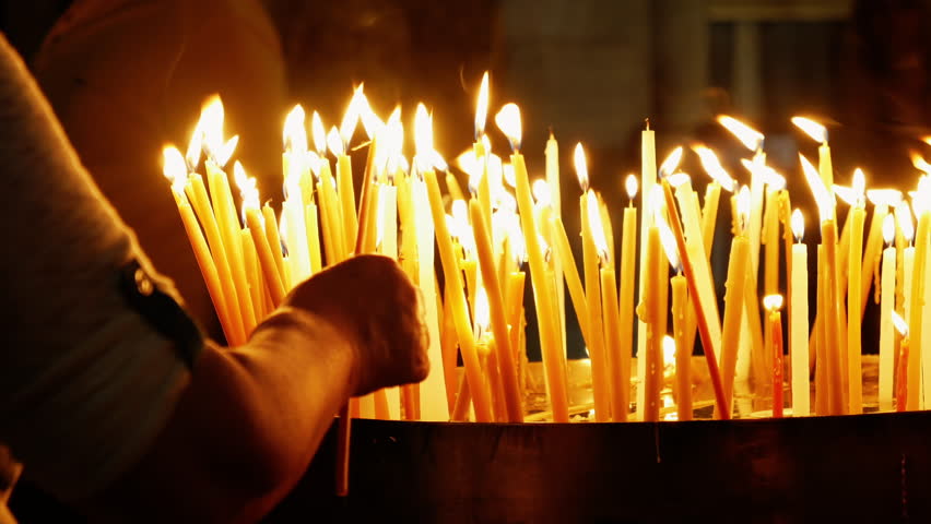 Burning candles in the Holy Sepulcher Church in Jerusalem. The Holy Sepulchre Church and Empty Tomb are the most sacred places for all religious Christians in the world.