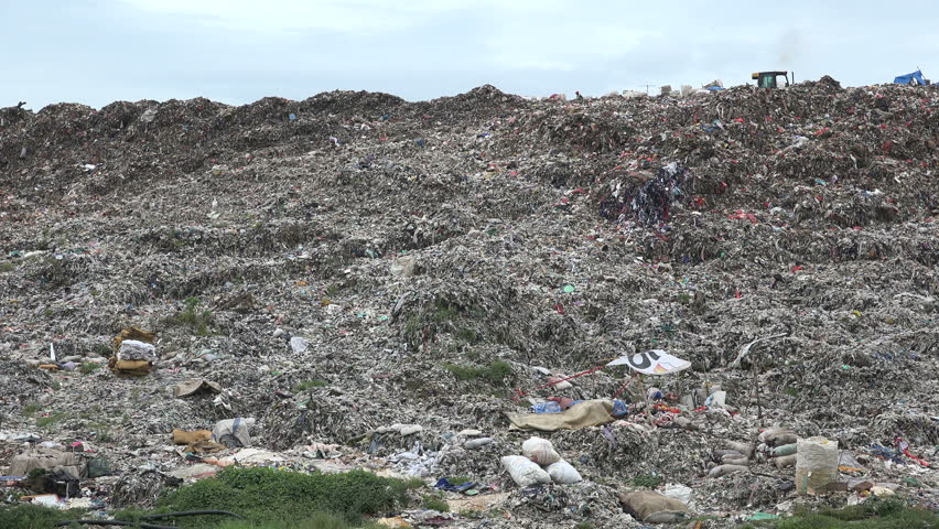 JAKARTA, INDONESIA - APRIL 2017: Lonely figure recycles garbage on a massive dumping ground in Jakarta, Indonesia | Shutterstock HD Video #29469013