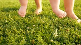 small baby's cute feet on the summer green grass. Full HD slow motion video