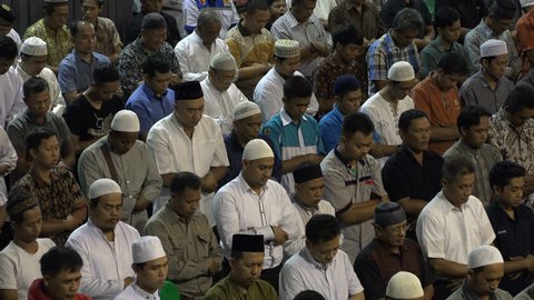 JAKARTA, INDONESIA - APRIL 2017: Muslim men contemplate and attend Friday prayer in Istiqlal mosque in Jakarta, Indonesia