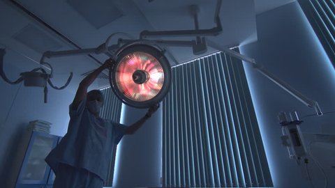 surgeon turns on light in hospital room 