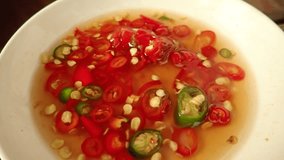 SLOW MOTION : Thai condiments (chili, fish sauce, sugar, vinegar) closeup on table