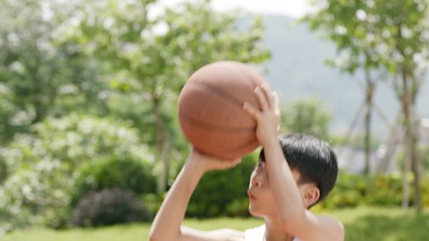 Asian little kid shooting basketball outdoor, slow motion
