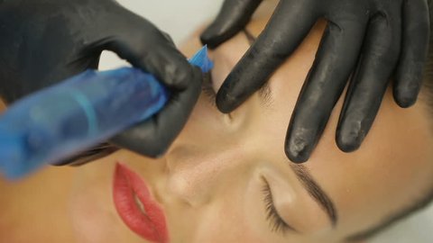 Cosmetologist making eyeliner permanent make up