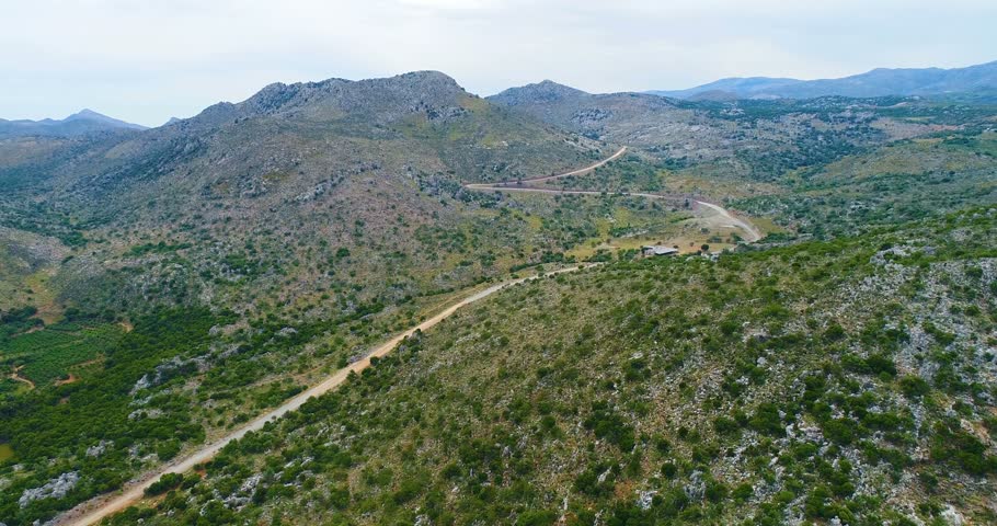 View of the mountains, olive trees and road  from a bird's eye view.