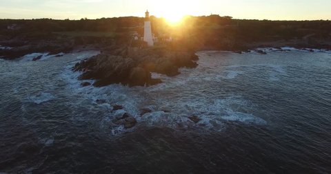 Lighthouse on Rocky Ocean Point during Sunset with Active Light - Aerial Footage of Portland Head Lighthouse, Maine, USA