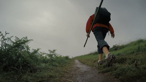Pilgrim woman walks by the Camino, the popular trekking route in the rainy season