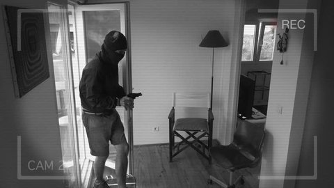 CCTV Camera Records A Home Burglary. Burglar with a gun breaks Into a house filmed on home security camera