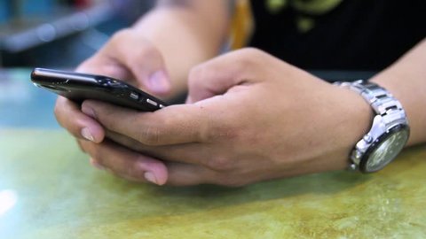 Close up of a man's hand typing fast on a smartphone for mobile working