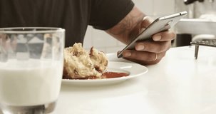 closeup of mixed race man's hand texting in smartphone during breakfast with milk on a first plane