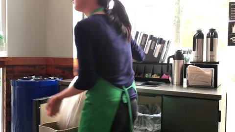 Coquitlam, BC, Canada - August 05, 2017 : Motion of worker cleaning garbage inside Starbucks store with 4k resolution.