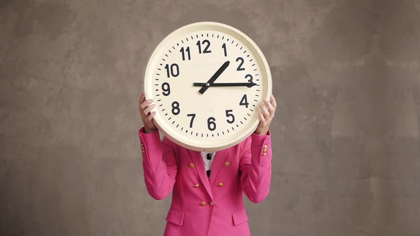 Businesswoman holding retro clock and smiling, time concept