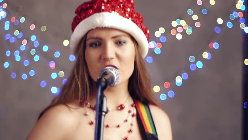 Beautiful woman in santa claus singing song