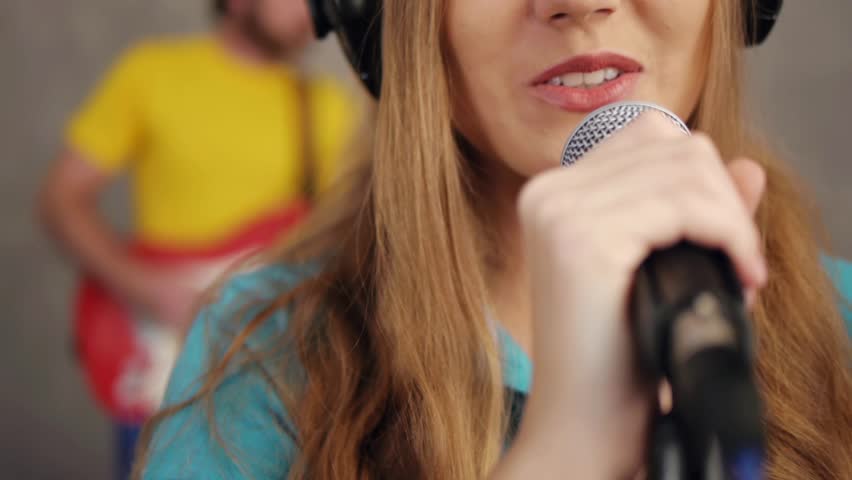 Close-up of woman singing and recording song in studio