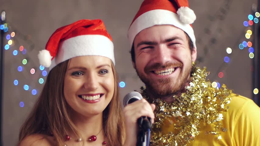 Couple singing karaoke at Christmas party