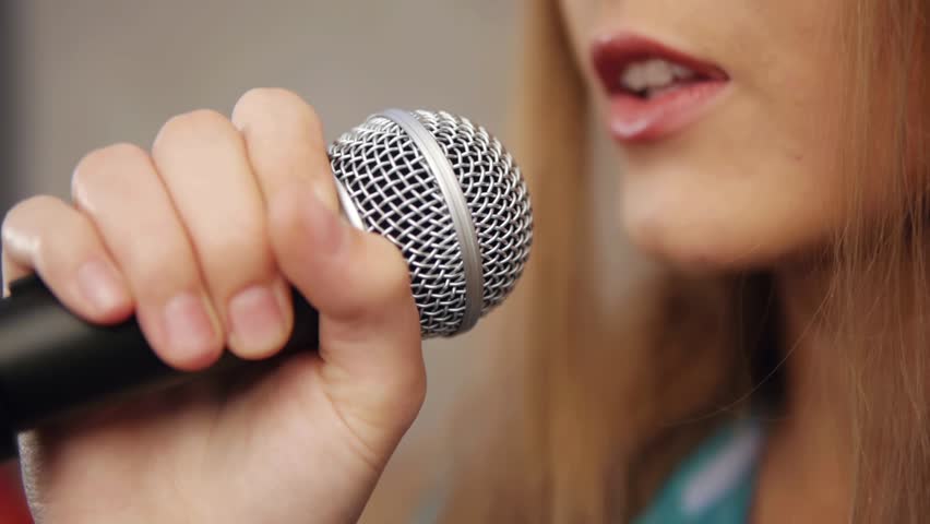 Close-up of singer touching microphone singing