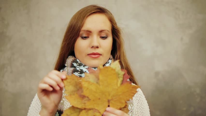 Pretty woman in scarf throws up leaves