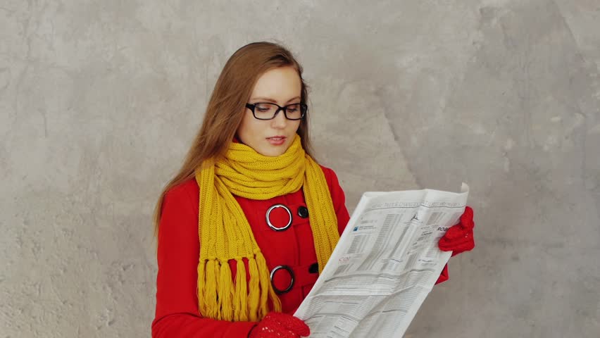 Young elegant woman reading newspaper