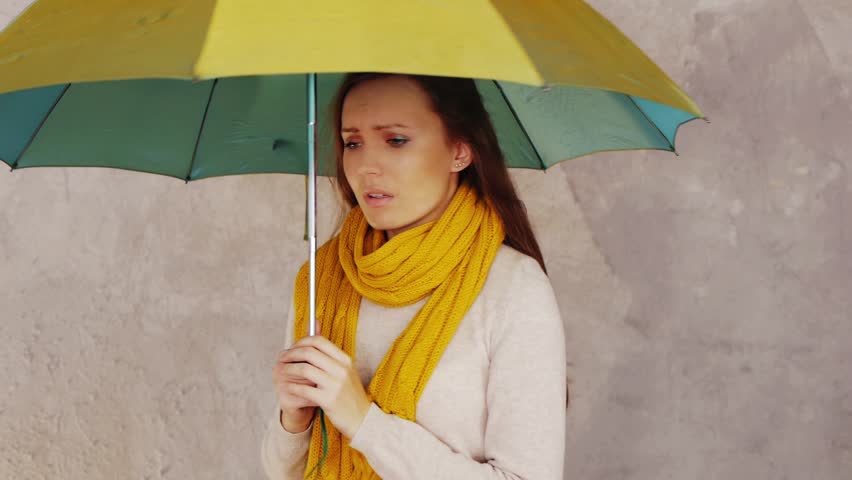 Young woman with umbrella showing her depression