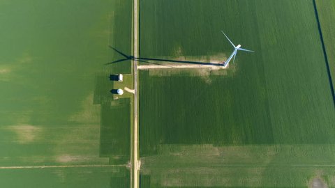 Aerial Top View of wind farm and barns on green agriculture field