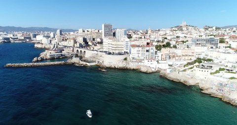 Aerial : Flying over Marseille  beautiful coastline . Cityscape panorama with edifice of Notre Dame de la Garde and Old port at summer sunny day.  France