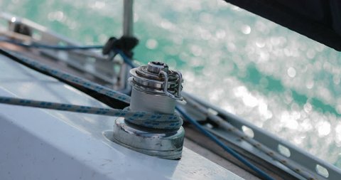 Sailing, man pulling ropes, winding sheets around winches. close-up.  real time