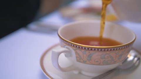 Tea pouring into cup 