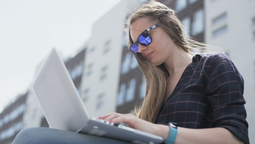 Businesswoman Using a Laptop Computer in Strong Wind