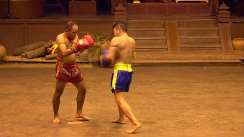 NAKORN PATHOM, THAILAND - MARCH 22nd: Two men participate in a Muay Thai boxing exhibition at Thai Village near Bangkok, Thailand on March 22nd, 2017.