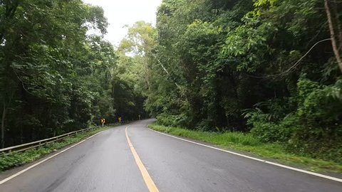 Driving along a curving road through the Inthanon mountain and forest in Thailand in the morning
