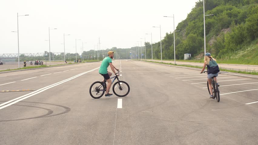 Young couple cycling in town. Slow Motion