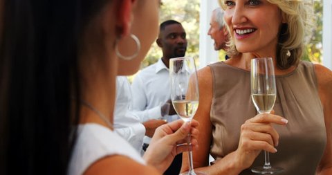 Friends interacting with each other while having champagne in restaurant