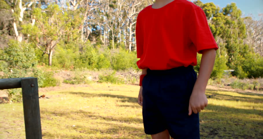Determined boy walking on obstacle in boot camp